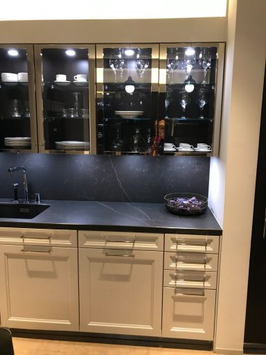 Cocina moderna reformada con encimera de piedra negra y gabinetes blancos con detalles en vidrio, Suárez & Co. Interiorismo.